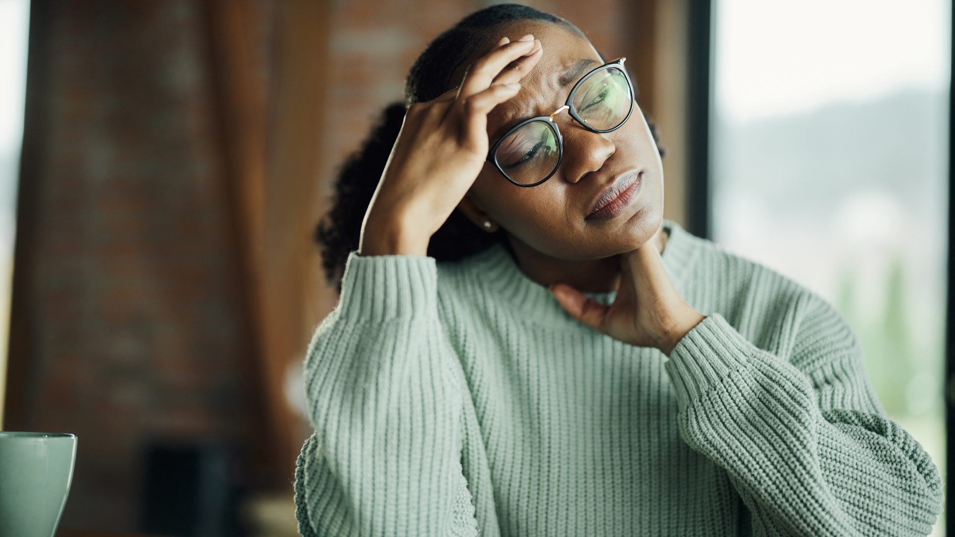 Women stretching her neck, looking stressed and fatigued